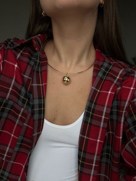 A ball pendant on a metal string with mother-of-pearl inserts